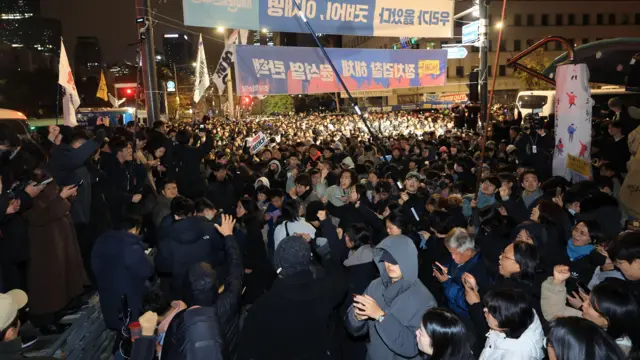 Des personnes se rassemblent devant l'Assemblée nationale à Séoul, en Corée du Sud, aux premières heures du 4 décembre 2024, pour demander le retrait de la loi martiale.