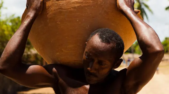 Retrato de homem negro carregando uma panela no Quilombo Itamatatiua, Maranhão, em 2015