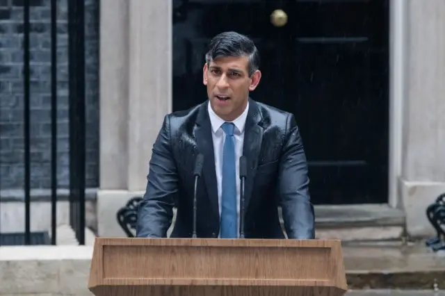 Rishi Sunak anunciando a convocação de eleições antecipadas sob forte chuva em Londres