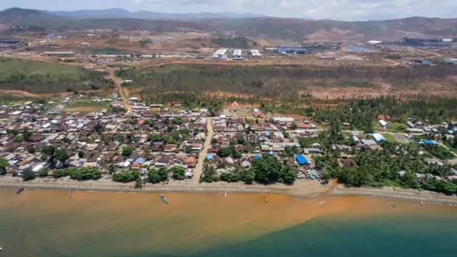 Red sediment pours from a river into the sea in the village of Kawasi in October 2022