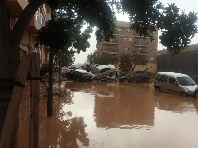 Rua inundada com carros amontoados