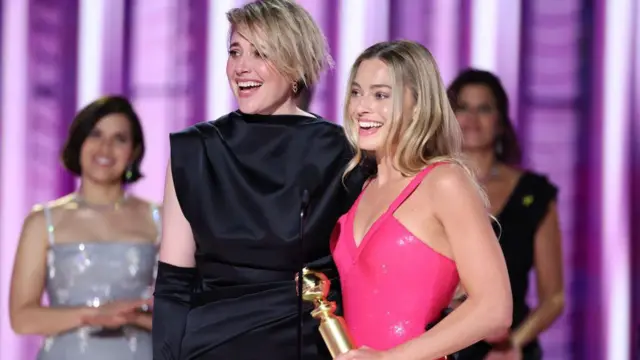 Greta Gerwig e Margot Robbie com o Globo de Ouro pelo maior feito cinematográfico de bilheteria da Barbie.