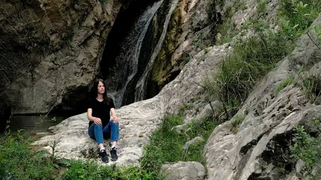 Mulher meditando em uma pedra 