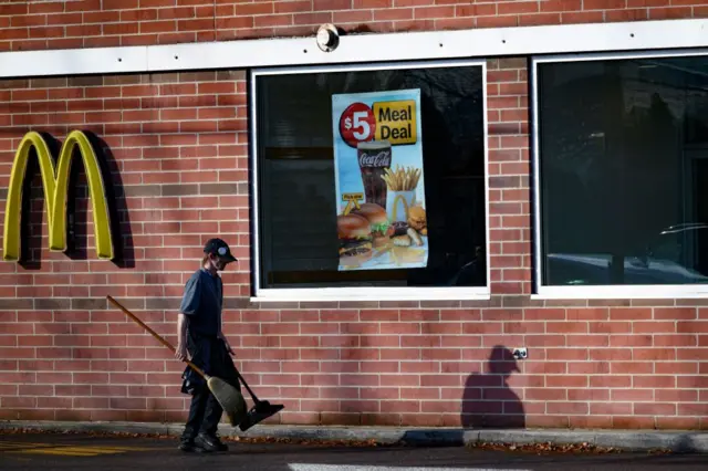 Um funcionário passando pelo McDonald's onde Luigi Mangione foi identificado e posteriormente preso em 9 de dezembro de 2024 em Altoona, na Pensilvânia