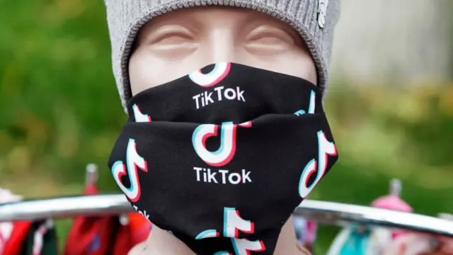 Manequim com bandana escrito TikTok cobrindo o rosto