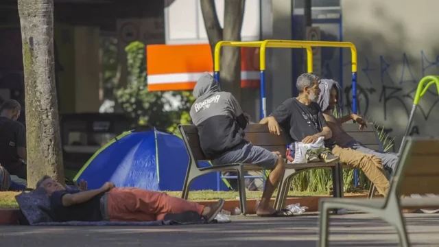 Homens deitados e conversando em praça de São Paulo