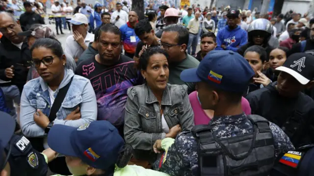 Manifestantes próximos de policiais na Venezuela