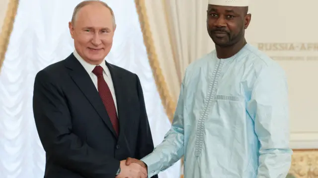 Le président russe Vladimir Poutine serre la main du président malien Assimi Goita.