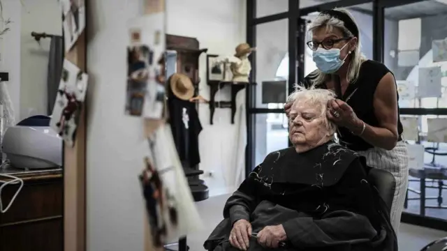 Paciente com Alzheimer corta o cabelo na aldeia Landais Alzheimer, local para pacientes com Alzheimer em Dax, sudoeste da França