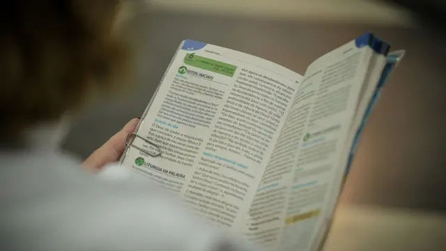 Fiel de costas lendo revista com conteúdo católico