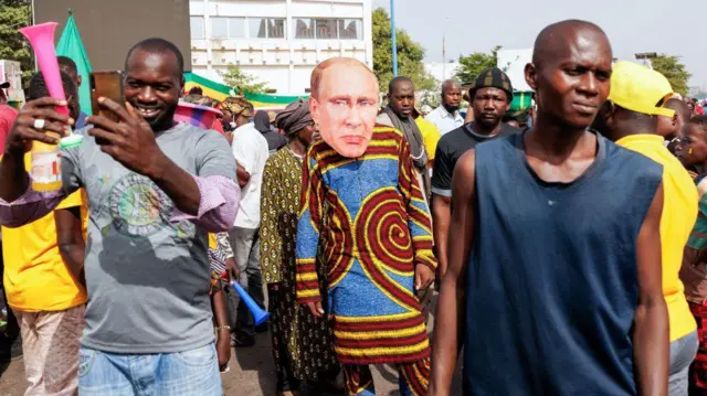 Un partisan de la junte malienne porte un masque à l'effigie du président russe Vladimir Poutine lors d'un rassemblement à Bamako le 13 mai 2022.