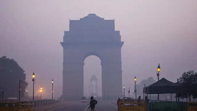 Police officers stand guard at the India Gate monument shrouded in smog in New Delhi, India. Photographer: Prashanth Vishwanathan/Bloomberg