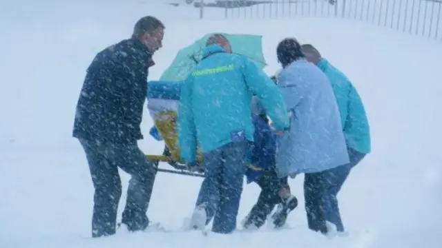 Kees Veldboer movendo um paciente em uma maca durante neve forte