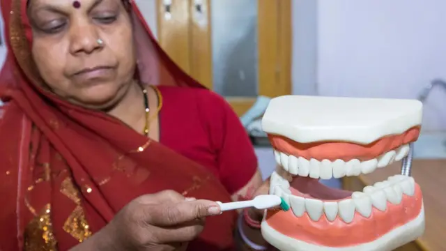 Mulher escovando dentadura gigante