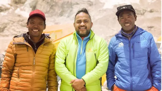 Brothers Lakpa (L) and Kami Rita (R) pose for a photo with a host a visiting filmmaker (C)