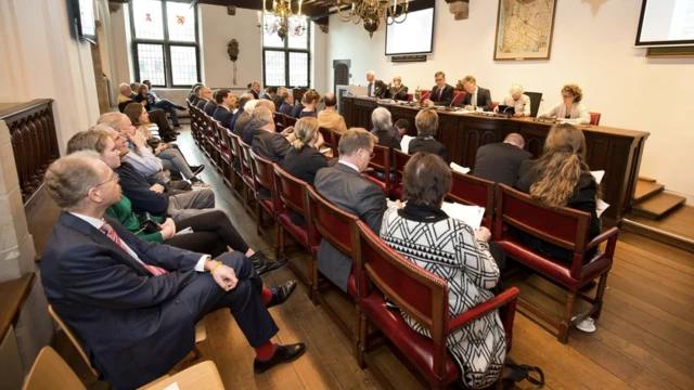 pessoas sentadas em sala de reuniões