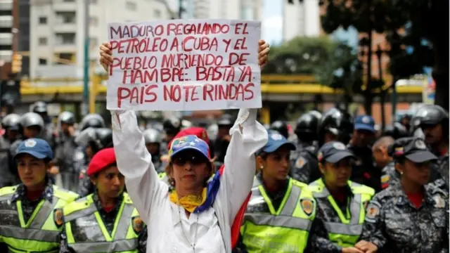 Manifestante segura cartaz criticando Maduro em protesto em Caracas