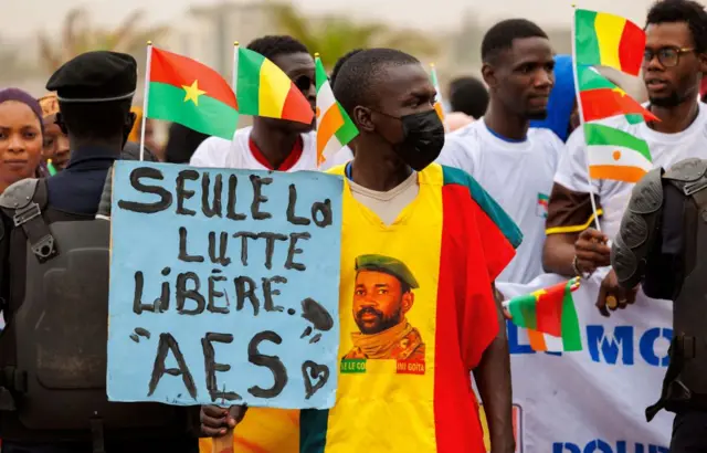 Un partisan de l'Alliance des États du Sahel (ASS) tient une pancarte sur laquelle on peut lire "Seule la lutte libère" lors d'un rassemblement pour célébrer le départ du Mali, du Burkina Faso et du Niger de la Communauté économique des États de l'Afrique de l'Ouest (CEDEAO), à Bamako, le 1er février 2024.