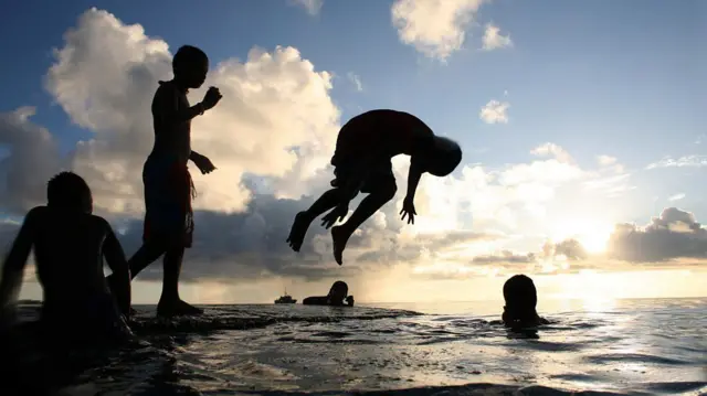 Crianças brincando no mar