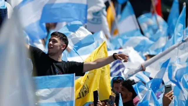 Apoiadores de Milei segurando bandeiras da Argentina