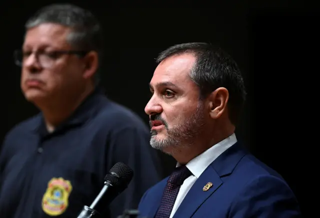 Andrei Rodrigues, um homem branco, de cabelo escuro e barba grisalha, fala no microfone