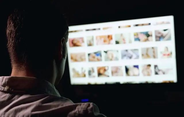 Un homme regarde des images sexualisées de femmes sur Internet