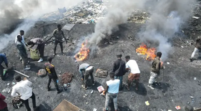 Homens queimando cabos e plásticos no lixão de Agbobloshie