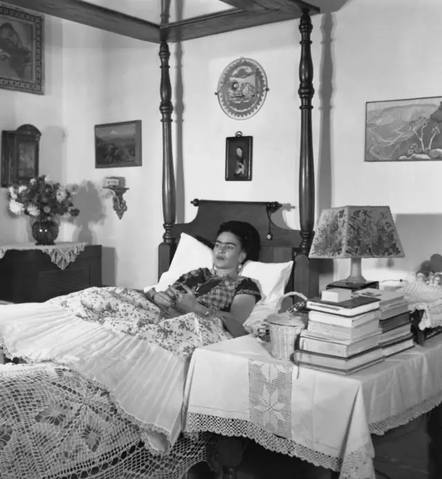 Frida Kahlo deitada na cama, em foto em preto e branco