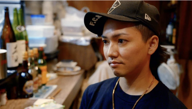 Ryu - jovem em bar usando boné de beisebol