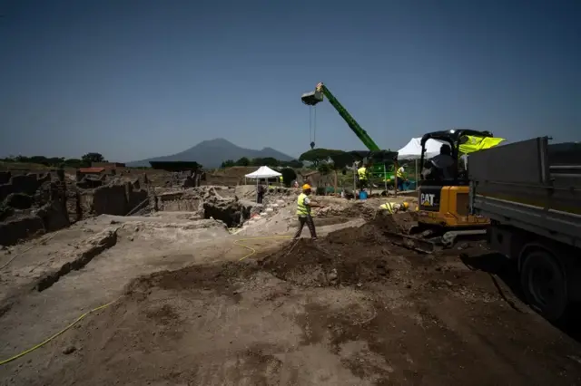 Trabalhos de escavação em andamento no calor escaldante do verão, à sombra do Monte Vesúvio