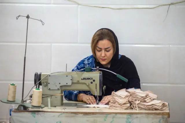 Uma mulher iraniana trabalhando como costureira em uma fábrica de lingerie em Teerã