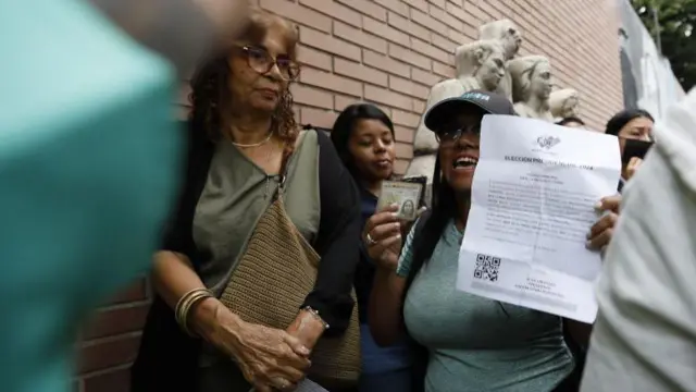 Mulher mostra sua identidade com uma carta na fila de votação