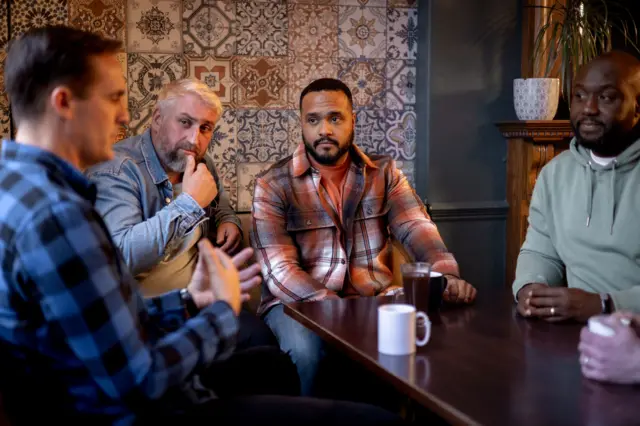 Um grupo de amigos conversando em uma mesa de restaurante