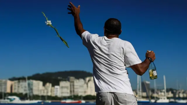 Homem joga flor no mar