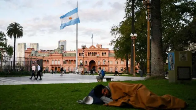 Um homem dormindo na Plaza de Mayo, em frente à Casa Rosada.