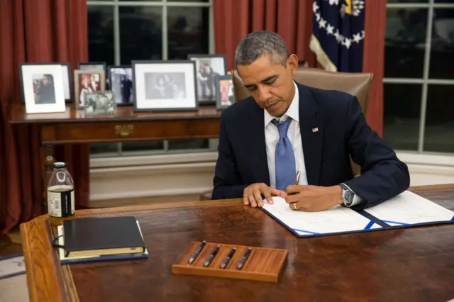 Barack Obama assinando documento no Salão Oval, na Casa Branca