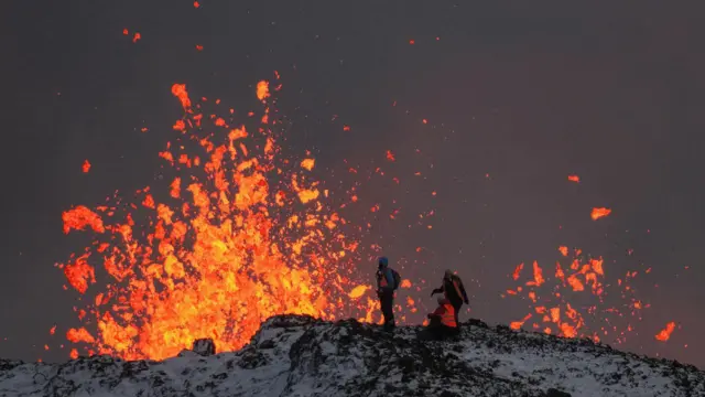 Pessoas observando lava de vulcão