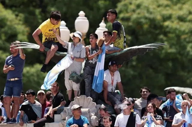 Apoiadores de Milei em cima de monumento em Buenos Aires