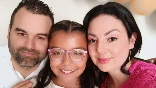 Victoria, o marido e a filha, de 9 anos em foto sorrindo lado a lado