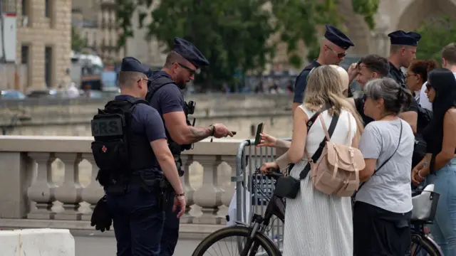 Pessoas fazem fila para passar por posto de controle em Paris