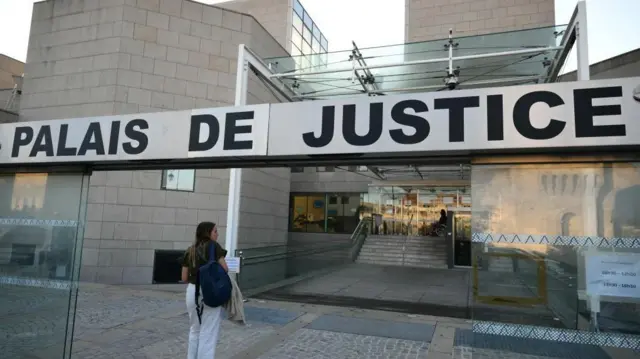 Foto de uma mulher de costas, caminhando em direção a um tribunal. Na entrada, é possível ler 'Palais de Justice' (Palácio da Justiça). 