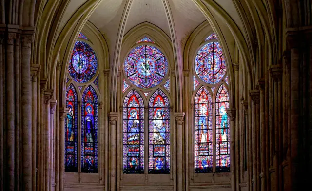 Vitrais intrincados em muitas cores são vistos decorando o telhado e a estrutura das paredes da catedral, quando vistos de dentro