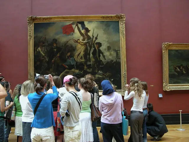 Pessoas olhando as pinturas no museu do Louvre 