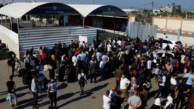 Palestinos se reúnem do lado de fora da passagem de fronteira de Rafah com o Egito