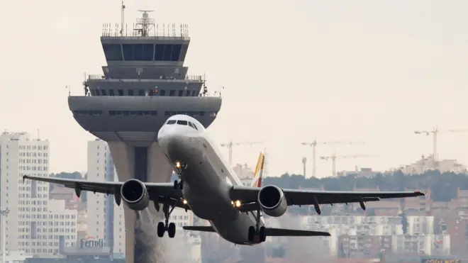 A imagem mostra um avião decolando em um aeroporto. 