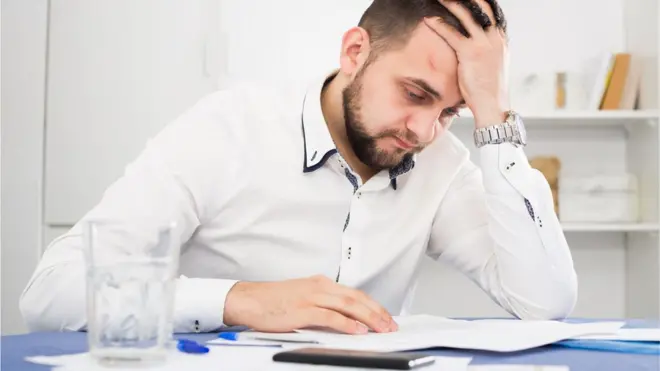 Homem preocupado com dívidas