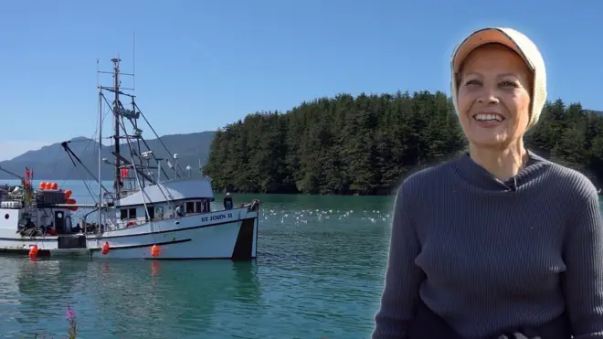 Imigrante diante de imagem de barco pesqueiro no Alasca