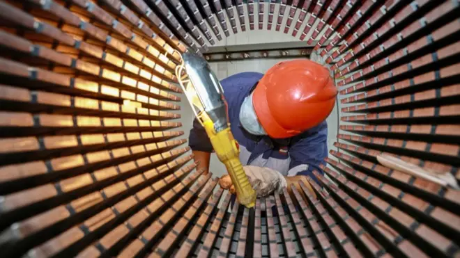 在中國東部江蘇省南通市的一家工廠裏，一名工人正在檢查風力渦輪機使用的轉子鐵芯。