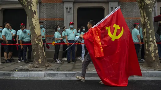 上海中共一大会址纪念馆外一位参观者举着党旗走过（17/6/2021）