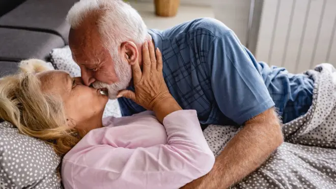 Pareja de adultos besándose.